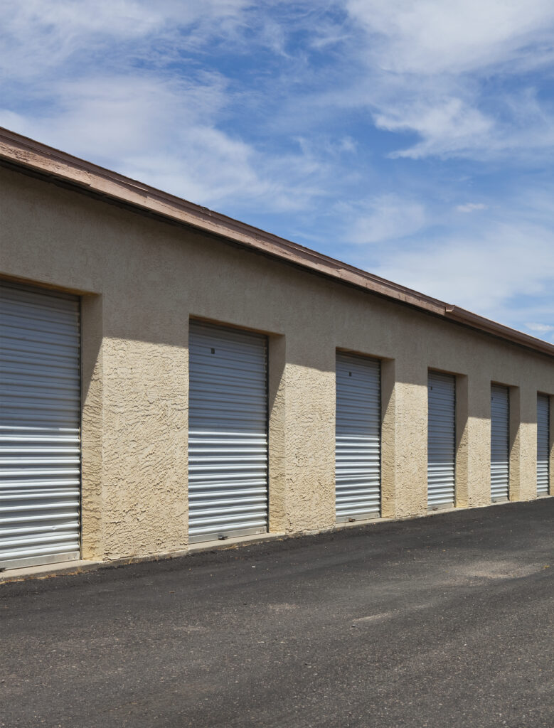 A row of storage units with roll-up doors, recently painted as part of Victory Paints & Services Inc.'s commercial painting services in Murrieta, CA.