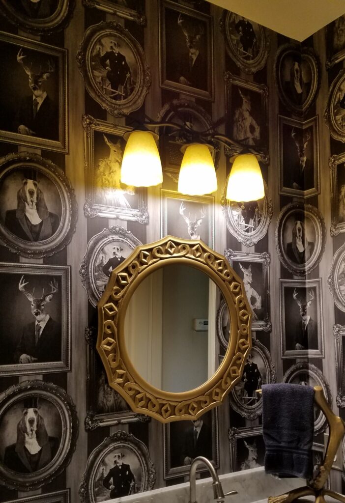 Before the wallpaper removal service, an eclectic bathroom in Riverside, CA showcases unique animal portraits wallpaper.