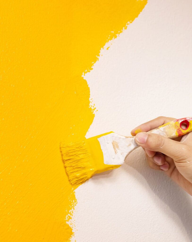 Bold yellow accent wall being painted by Victory Paints & Services Inc. in Riverside, CA.