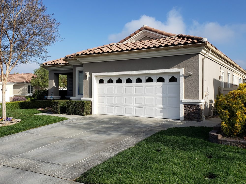 A freshly painted single-story house with a beige exterior and terra cotta roof tiles, exemplifying quality house painting services in Riverside.