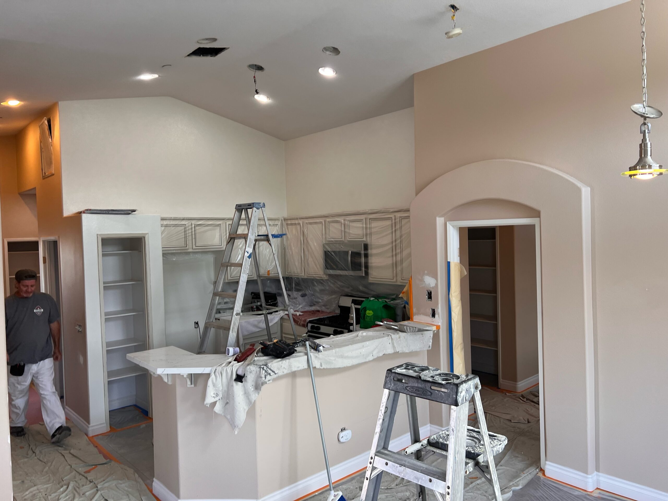 Interior of a home being painted with ladders and painting supplies, showcasing painting services in Riverside, CA