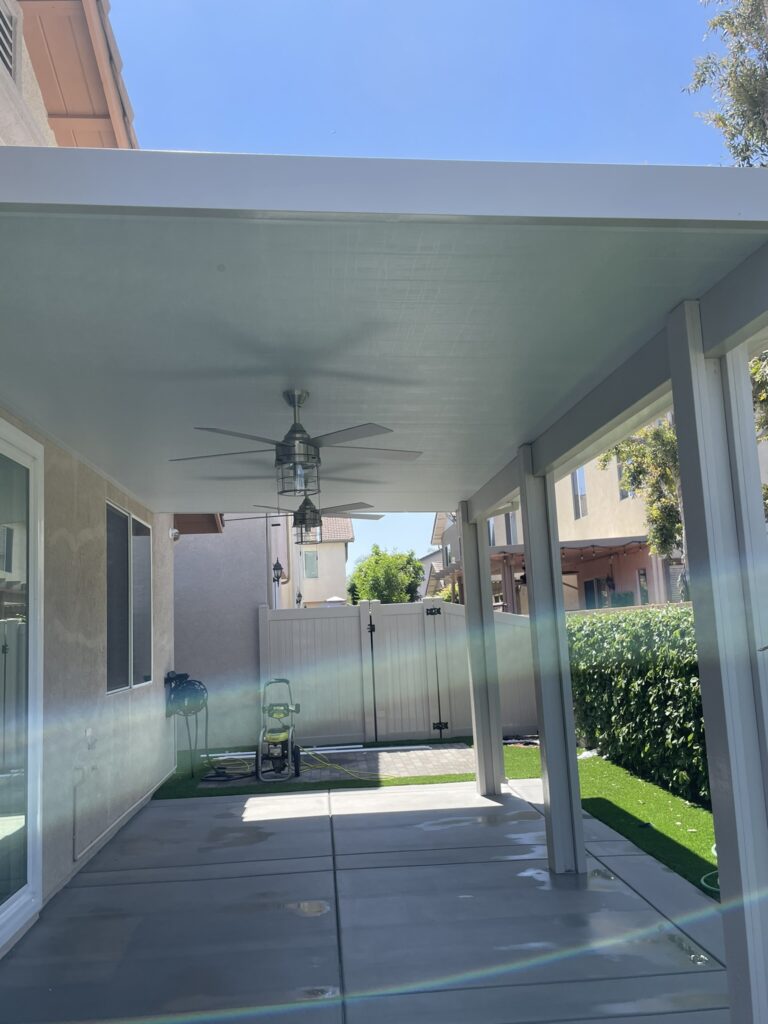 Outdoor patio with a modern ceiling fan, freshly painted by a painting company in Moreno Valley, CA, featuring a clean and bright space under a covered patio.