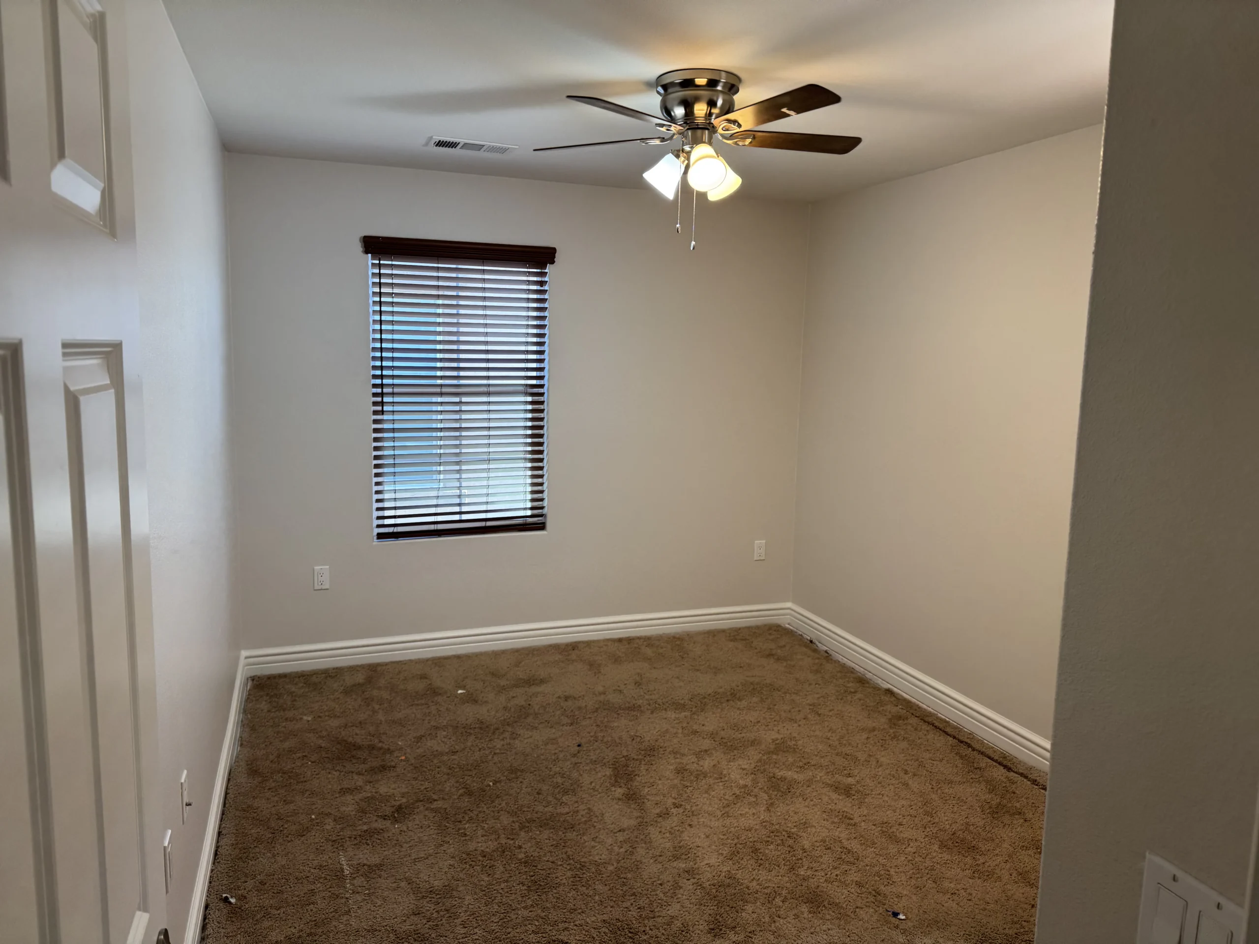 Freshly painted bedroom with neutral walls and carpet