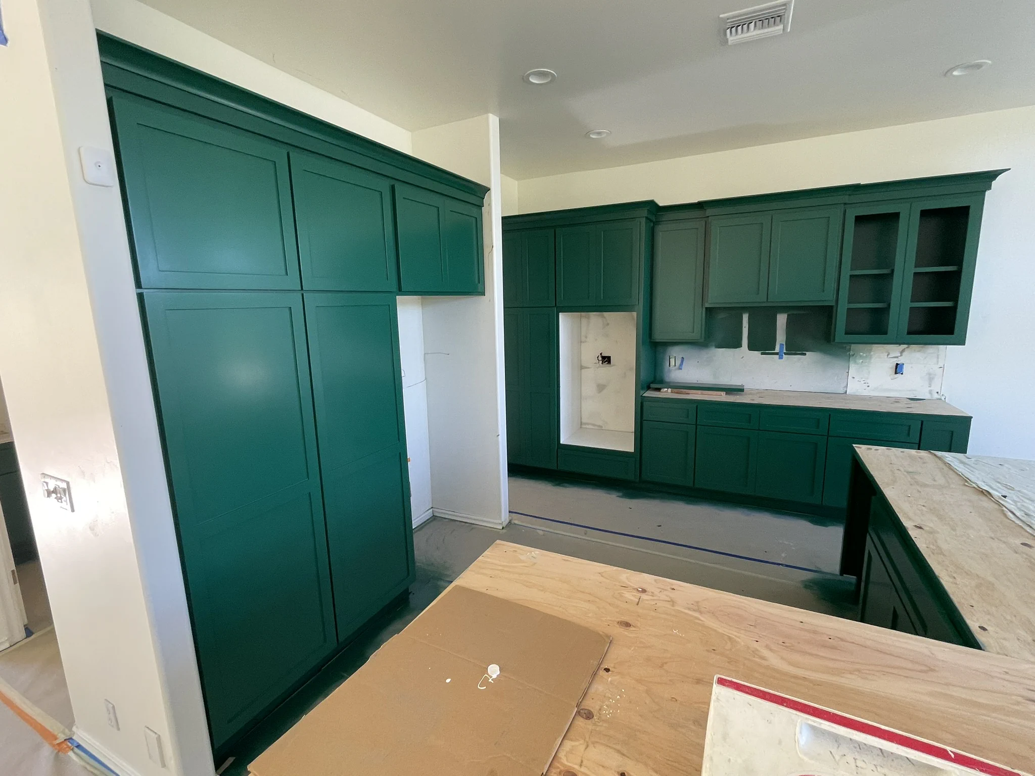 Kitchen cabinets being refinished with a bold teal paint color