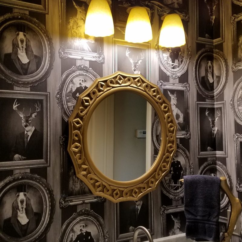 Before the wallpaper removal service, an eclectic bathroom in Riverside, CA showcases unique animal portraits wallpaper.